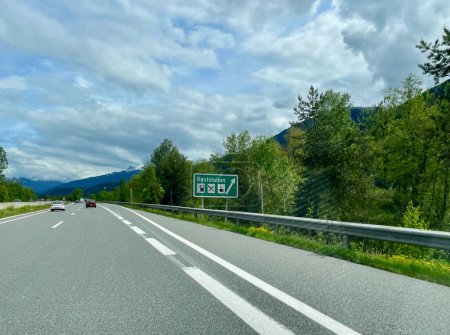 Téléchargez les photos : Autoroute autrichienne avec panneau indiquant Raststation, aire de repos de l'autoroute. Photo de haute qualité - en image libre de droit