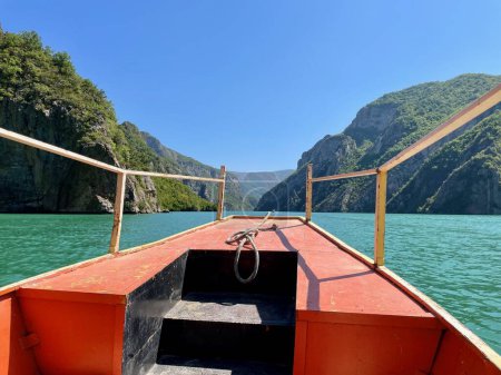 Téléchargez les photos : Bateau rouge sur le lac Komani, réservoir dans les Alpes albanaises. Photo de haute qualité - en image libre de droit