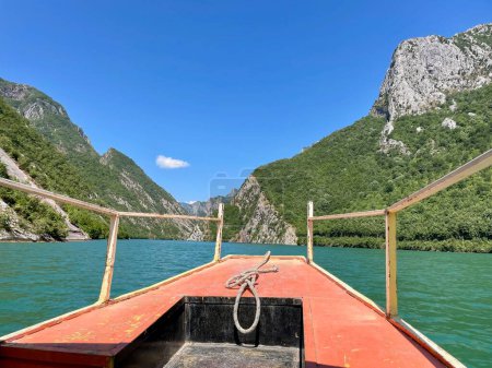 Téléchargez les photos : Bateau rouge sur le lac Komani, réservoir dans les Alpes albanaises. Photo de haute qualité - en image libre de droit