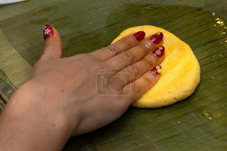 Maismehl auf Bananenblatt verteilen, um Hallaca oder Tamale zuzubereiten
