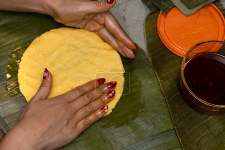 Maismehl auf Bananenblatt verteilen, um Hallaca oder Tamale zuzubereiten