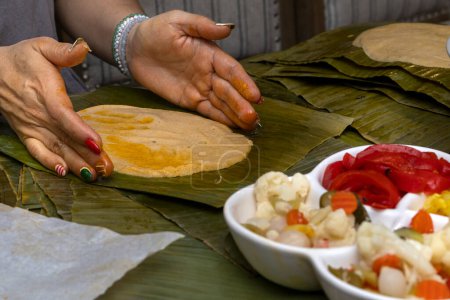 Frauenhände mit Maisteig zur Zubereitung von hallaca oder tamale