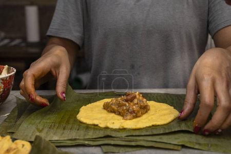 Preparation and ingredients of a Hallaca or tamale wrapped in banana leaf.