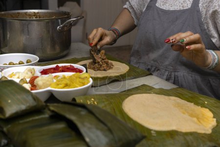 Preparation and ingredients of a Hallaca or tamale wrapped in banana leaf.