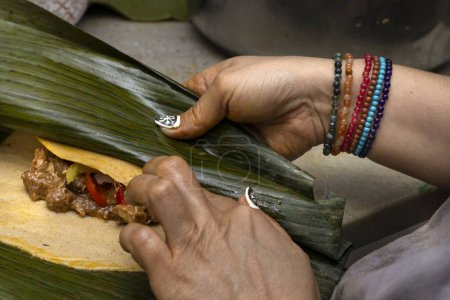 Zubereitung und Zutaten eines Hallaca oder Tamale in Bananenblatt gewickelt.