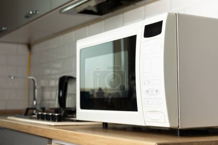 Foto de Moderno microondas blanco en la encimera de la cocina.Uso de microondas todos los días en la cocina. El concepto de cocinar. - Imagen libre de derechos