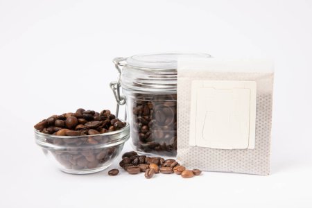 Téléchargez les photos : Sac goutte à goutte de café frais avec grains de café isolés sur fond blanc. Café moulu pour le brassage dans une tasse - en image libre de droit