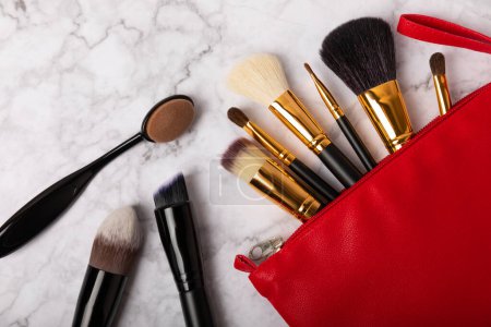 Cosmetic makeup brush in a cosmetic bag on the table. Cosmetic product for make-up. Creative and beauty fashion concept. Fashion. Collection of cosmetic makeup brushes, top view, banner.Place for text.
