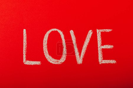 Foto de Chalk lettering ST. VALENTINE'S DAY or LOVE on a red textural background. - Imagen libre de derechos