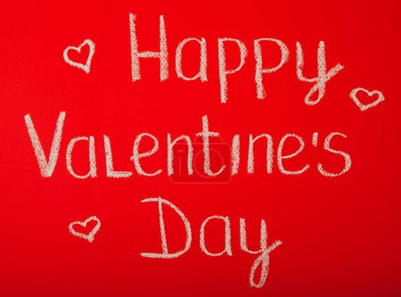 Foto de Chalk lettering ST. VALENTINE'S DAY or LOVE on a red textural background. - Imagen libre de derechos