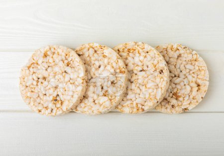 Téléchargez les photos : Stack of crispy rice cakes on white texture wood. Diet bread. Diet. proper nutrition. GLUTEN FREE. Copy space. Place for text. - en image libre de droit