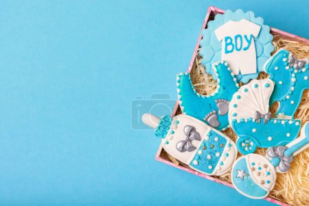 Foto de Set of delicious baby shower cookies in a gift box on a blue background. Gender cookies.Baby shower party. Close-up. Flat lay. Place for text. - Imagen libre de derechos