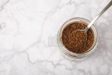 Photo for Instant coffee in a spoon. Coffee in granules on a white marble background.Energy hot drink. Place for text. Place for copy. Cheerful morning concept. - Royalty Free Image