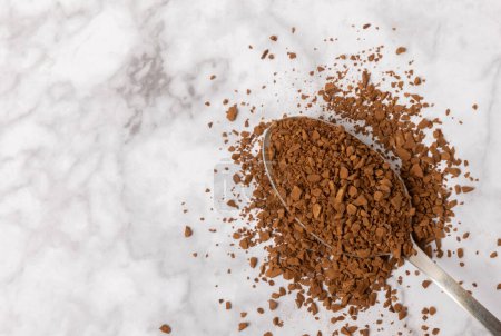 Photo for Instant coffee in a spoon. Coffee in granules on a white marble background.Energy hot drink. Place for text. Place for copy. Cheerful morning concept. - Royalty Free Image