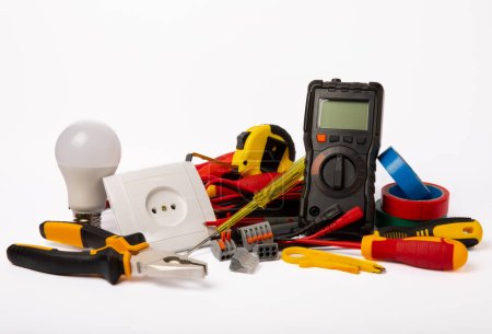 Foto de Electrician tools isolated on white background.Electrician tools set. Multimeter, construction tape, electrical tape, screwdrivers, pliers, LED lamp, socket, switch and automatic insulation stripper. - Imagen libre de derechos