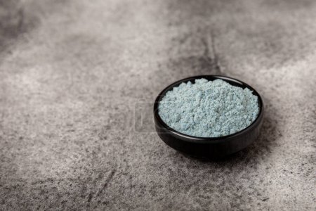 Téléchargez les photos : Blue spirulina powder in bowls on black texture background. Natural vegan superfood. Food supplement. Phycocyanin extract. Healthly food. Place for text. Copy space. - en image libre de droit