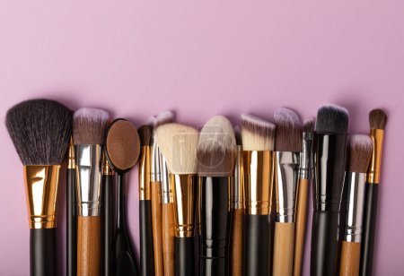 Set of cosmetic brushes on a lilac background. Makeup brushes. Makeup tool. Beauty concept.Professional brushes for applying cosmetics eyeshadows, make-up powder. Place for text. Copy space. Flat lay. Stickers 643828066
