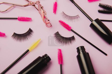 Composition with false eyelashes, mascara and eyelash brushes, eyelash curlers on a lilac background. Makeup artist tools. Beauty concept. Compose. Place for text. Place to copy. Flatley. MOCAP.