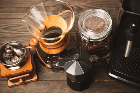 Kaffeezubereitung mit Chemex, Kaffeemaschine und Wasserkocher. Alternative Möglichkeiten, Kaffee zu brauen. Café-Konzept. Moka-Topf und Bohnen auf einem hölzernen Hintergrund. Raum für Text. Raum für Kopie.