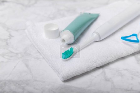 Téléchargez les photos : Brosse à dents électrique et dentifrice sur une serviette blanche sur le fond de la salle de bain. Brosse à dents électrique intelligente. Dentisterie saine concept. - en image libre de droit