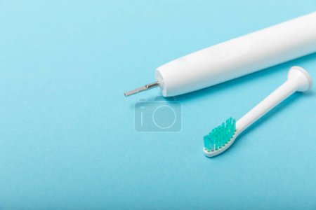 Téléchargez les photos : Brosse à dents électrique sonique sur fond bleu. hygiène buccale. Soins dentaires. Concept de dentisterie. Endroit pour le texte. Endroit pour copier. - en image libre de droit