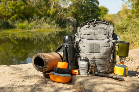 Backpack, thermos, gas burner, sleeping mat, knife, compass and tourist utensils in the mountains. Tourist equipment. place for text. Travel and hipster concept.Camping.Vacation. summer holidays.