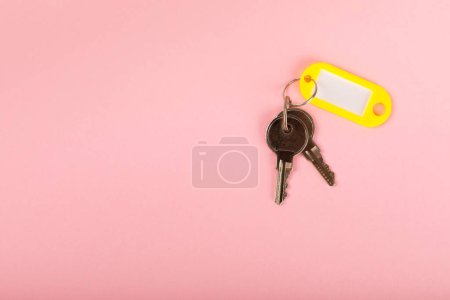 Porte-clés en plastique de différentes couleurs avec un endroit pour une signature sur un fond de couleur vive. Lot de clés avec porte-clés. Porte-clés maquette.Espace photocopie.Concept de location et de vente de biens immobiliers.