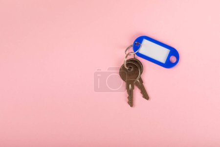 Plastic key ring in different colors with a place for a signature on a bright colored background. Bunch of keys with keychain. Mock-up keychain.Copy space.Concept for renting and selling real estate.