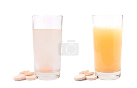 Foto de Comprimidos efervescentes de vitamina C con gotas de sabor a naranja y se disuelven en un vaso de agua aislado sobre un fondo blanco. El concepto de salud. Concepto de medicina. - Imagen libre de derechos