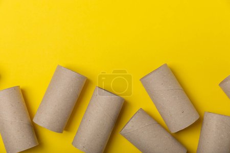 Empty toilet paper roll. Empty toilet paper rolls for the toilet, on a bright yellow background. Paper tube of toilet paper. Place for text. Copy space. Flat lay. Eco-friendly reuse recycle