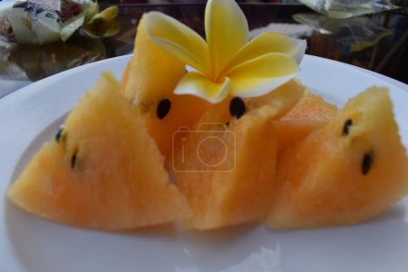 Photo for Yellow watermelon pieces on a white plate - Royalty Free Image
