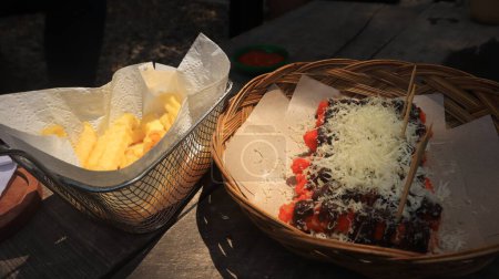 Téléchargez les photos : Snacks sont servis sur la table, pommes de terre et bananes frites saupoudrées de fromage - en image libre de droit