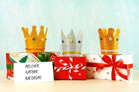 Téléchargez les photos : Trois couronnes des trois sages avec des boîtes-cadeaux de Noël sur fond bleu. Concept pour la journée Dia de Reyes Magos. Trois Sages - en image libre de droit