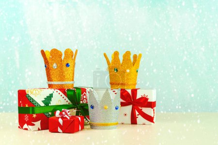 Téléchargez les photos : Trois couronnes des trois sages avec des boîtes cadeaux de Noël sur fond bleu. Concept pour la journée Reyes Magos. Trois Sages - en image libre de droit