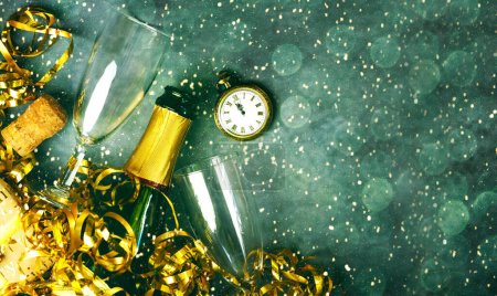 Photo for Happy New Year. Top view of champagne bottle,two glasses,golden streamers,antique clock and christmas lights with space for text over grunge background. New Years Eve celebration concept background - Royalty Free Image