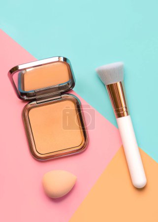 Photo for Makeup buffer brush with face powder and beauty makeup sponge over blue,yellow and pink background. Beauty and makeup concept - Royalty Free Image