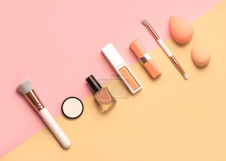 Photo for Top view of makeup brushes, eyeshadow, beauty makeup sponges,nail polish and lipstick over yellow and pink background. Beauty and makeup concept - Royalty Free Image
