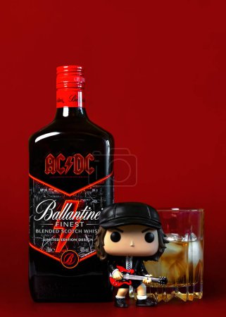 Foto de Ballantine 's escocés botella de whisky edición especial de la icónica banda de rock ACDC, con vaso de whisky escocés y Funko POP vinilo figura de Angus Young cantante sobre fondo rojo. Editorial ilustrativo - Imagen libre de derechos