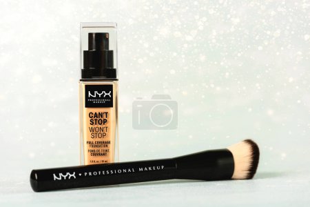 Photo for Makeup foundation bottle Can'stop won'stop Full coverage foundation NYX professional makeup and makeup brush over light background. NYX professional makeup Illustrative editorial - Royalty Free Image