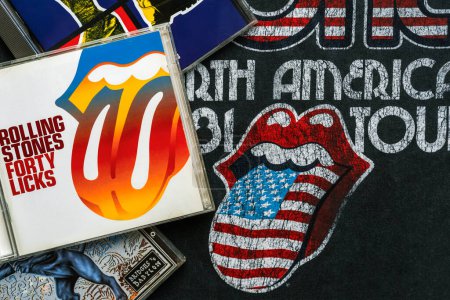 Téléchargez les photos : Les CD du groupe de rock britannique The Rolling Stones sur un T-shirt avec le logo The Rolling Stones. Éditorial illustratif - en image libre de droit