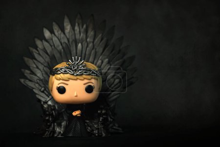 Photo for Funko POP vinyl figure of Cersei Lannister character of the TV series Games of thrones sitting on the iron throne over black background. Illustrative editorial of Funko Pop action figure - Royalty Free Image