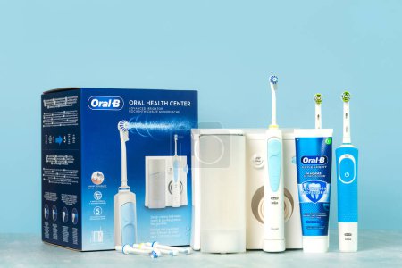 Téléchargez les photos : Arroseur de centre de santé buccodentaire Oral-B, brosses à dents électriques Oral-B Vitality et dentifrice Oral B sur une table bleue - en image libre de droit