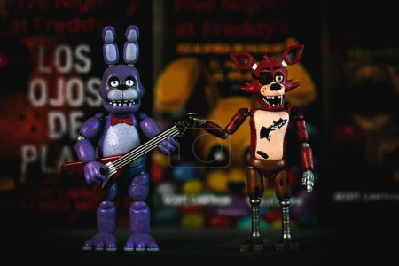 Foto de Figuras de Bonnie y Foxy personajes de los videojuegos, películas y libros Five Nights at Freddy 's delante de los libros. Editorial ilustrativo - Imagen libre de derechos