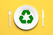 Top view of Symbol of recycling with white plastic cutlery and plate over yellow background. Eco friendly recycling concept Sweatshirt #708391944