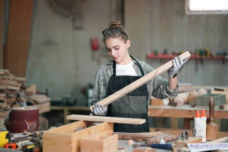 Photo for Small business of a young woman. Beautiful young woman worker in a furniture workroom - Royalty Free Image