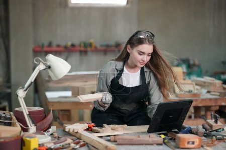 Photo for Small business of young woman. Beautiful young woman worker in a furniture workroom - Royalty Free Image