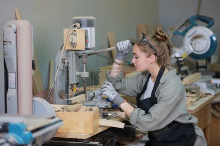 Foto de Pequeño negocio de una mujer joven. Hermosa joven trabajadora en un taller de muebles - Imagen libre de derechos