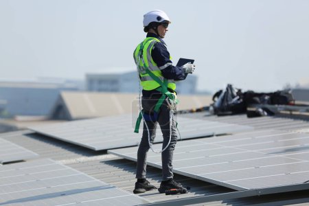 Téléchargez les photos : Ingénieur installant des panneaux solaires sur le toit. - en image libre de droit