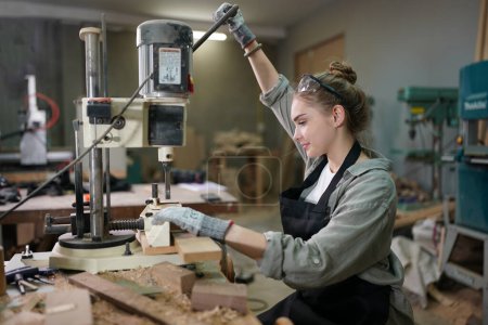 Foto de Pequeño negocio de una mujer joven. Hermosa joven trabajadora en un taller de muebles - Imagen libre de derechos
