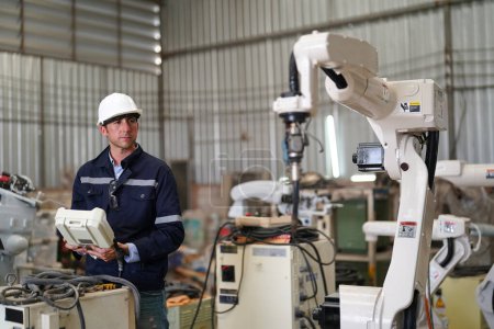 Foto de Ingeniero industrial que trabaja en la fábrica automatizada de producción robótica AI, nuevo concepto de tecnología industrial. - Imagen libre de derechos